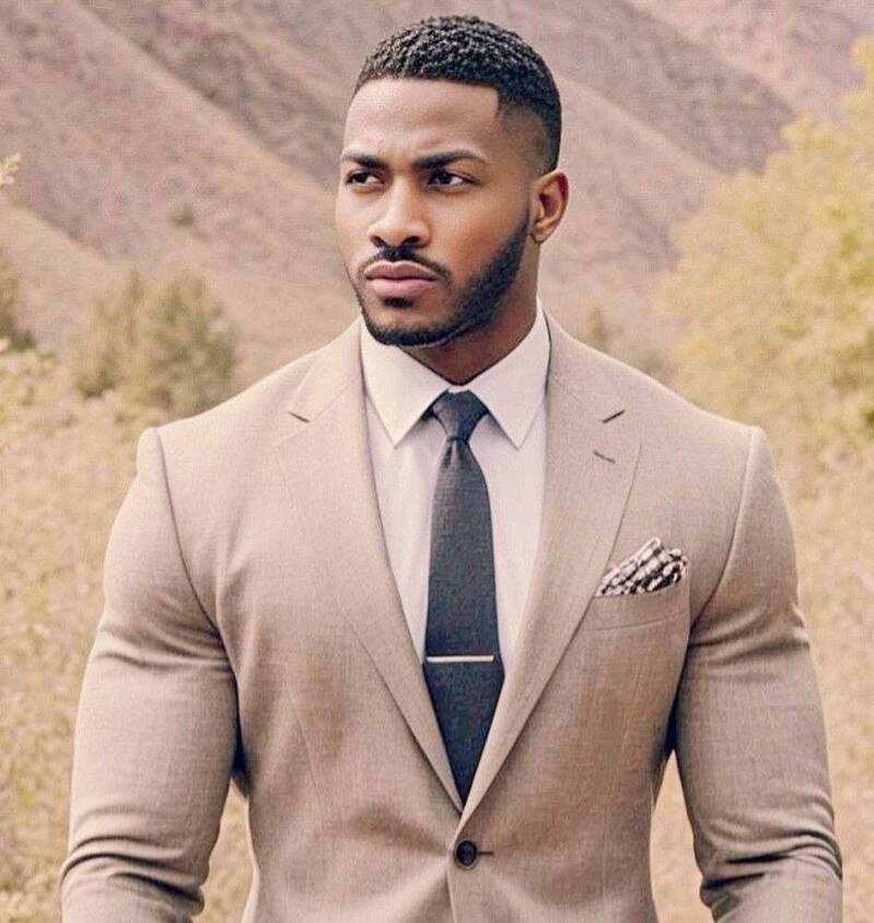 Confident and handsome Black man modeling a business suit against a nature background. Exuding sex appeal, determination, and a strong sense of self.