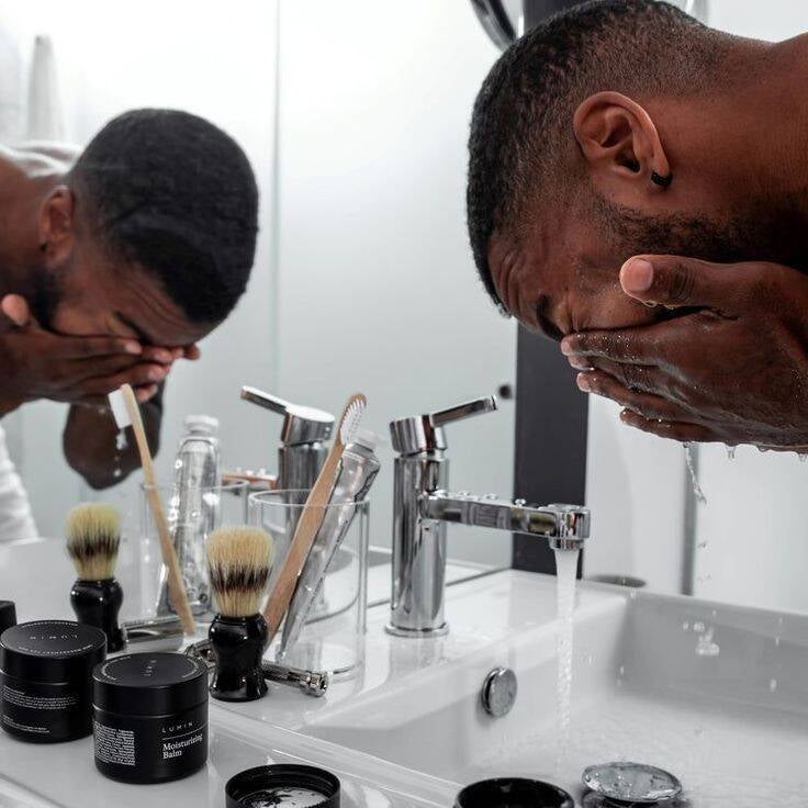 Man in his bathroom using self-care grooming products on his face. Illustrating that self-care and grooming is essential for men in 2025