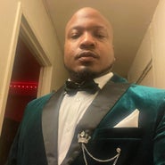 Mike El a bold Black male in a dark green shade suit positive five star review of BlackMaleBodyWorship.com
