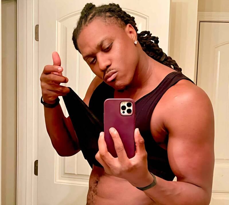 Scott keptsecret gay black pornstar in a black tank top lifting his shirt to show off stomach. Looking confident in bathroom selfie 