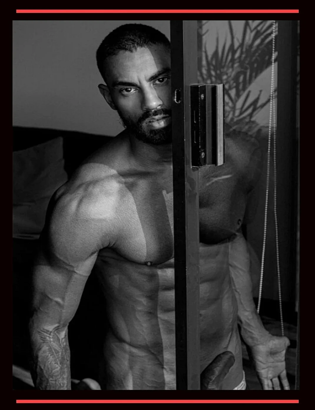 Aesthetic black and white portrait of a muscular man partially nude, standing behind a door. Representing shadow self and confronting the dark side of mental health