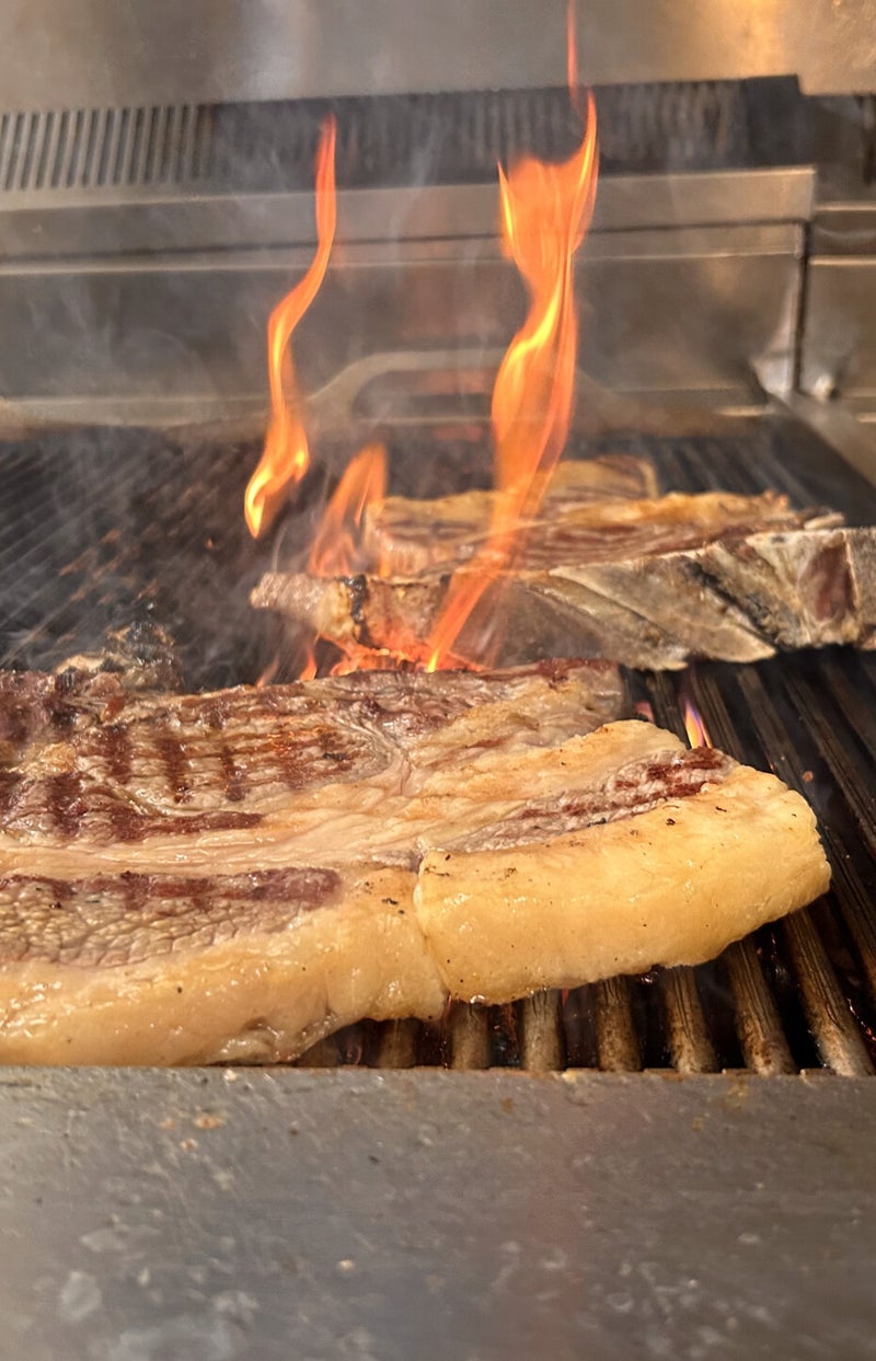 costata morbida che viene cotta sulla griglia fiammeggiante