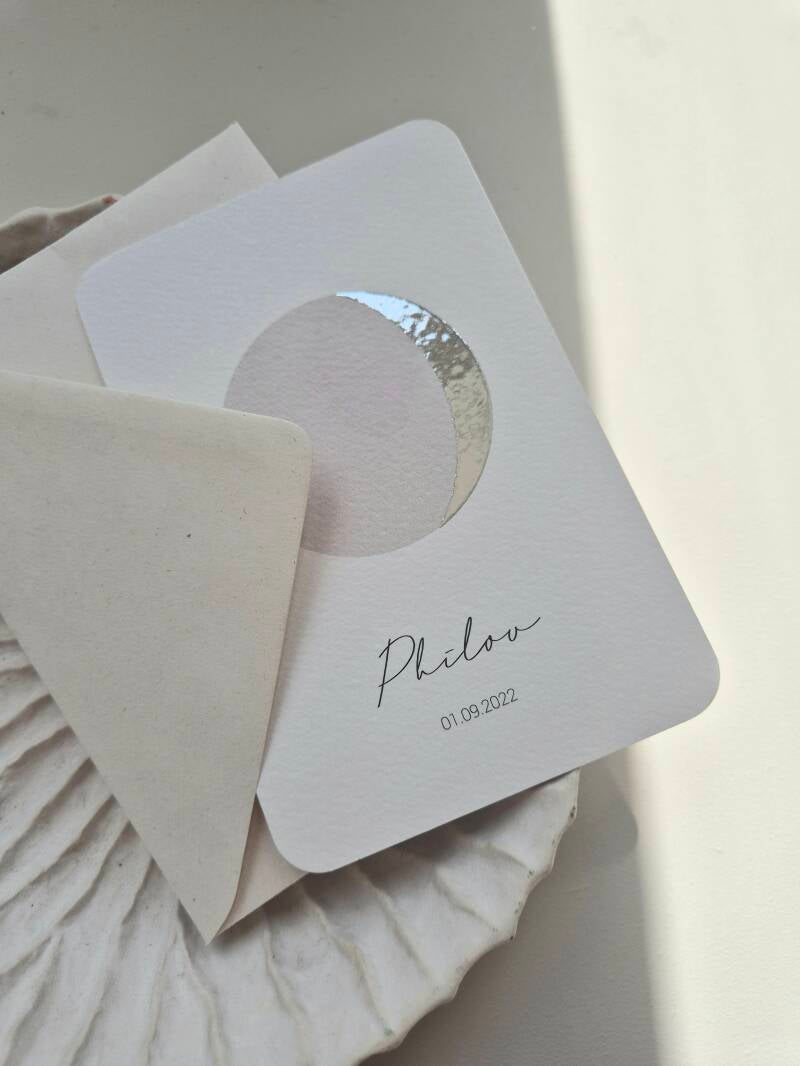 Dit prachtige kaartje weergeeft de maanstand  van de geboortedatum, hoe bijzonder ♡!  Het kaartje heeft een witte ondergrond en de maan wordt gedrukt in zilver foliedruk. De schaduwkant van de maan heeft een greige kleur. De afgeronde hoeken zijn helemaal