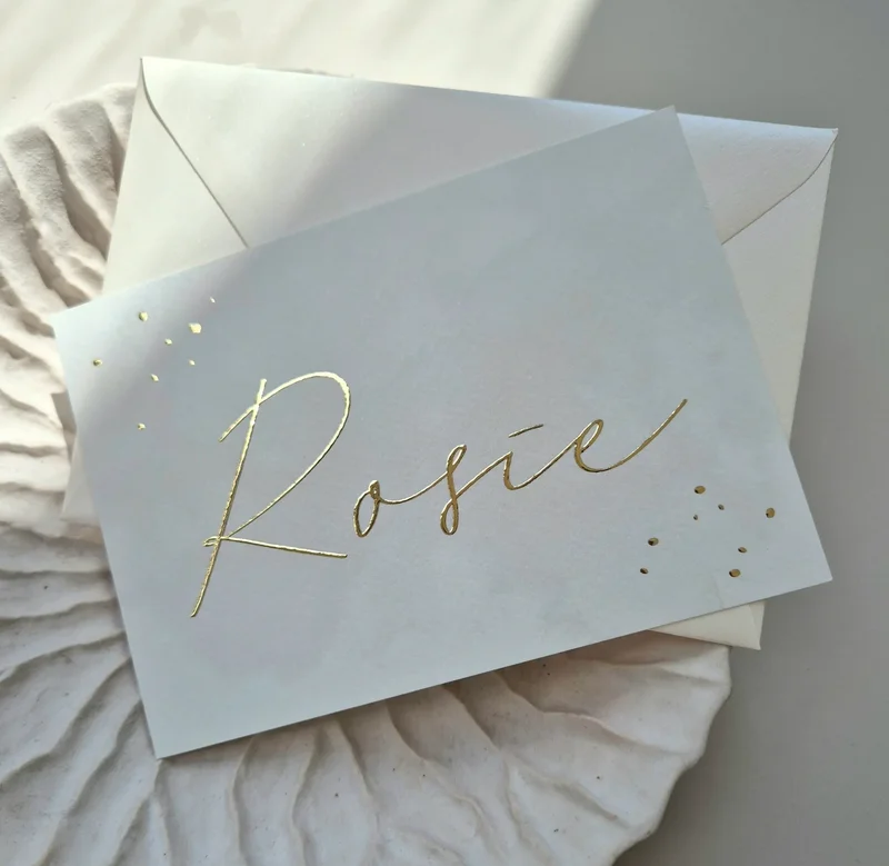 Een prachtig beige geboortekaartje met naam en spetters in goud foliedruk. Het kaartje heeft een licht watercolor effect op de achtergrond en op de achterzijde is er plaats voor de actuele maanstand bij de geboorte