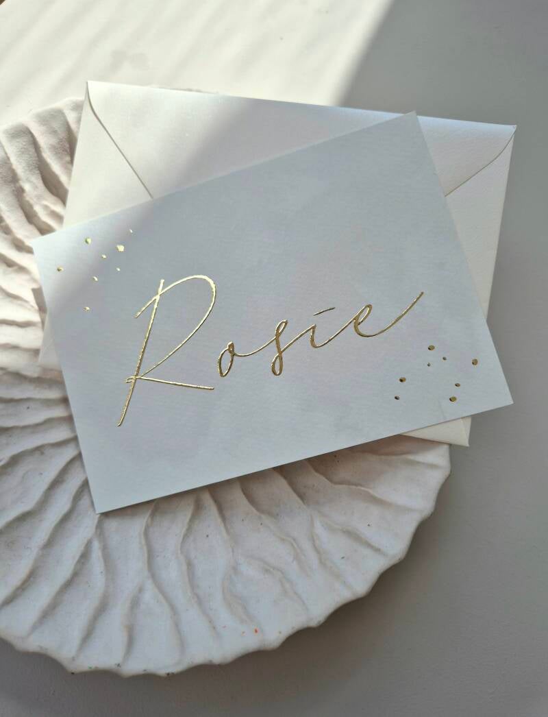 Een prachtig beige geboortekaartje met naam en spetters in goud foliedruk. Het kaartje heeft een licht watercolor effect op de achtergrond en op de achterzijde is er plaats voor de actuele maanstand bij de geboorte. Een bijzonder en uniek kaartje!  Zowel 