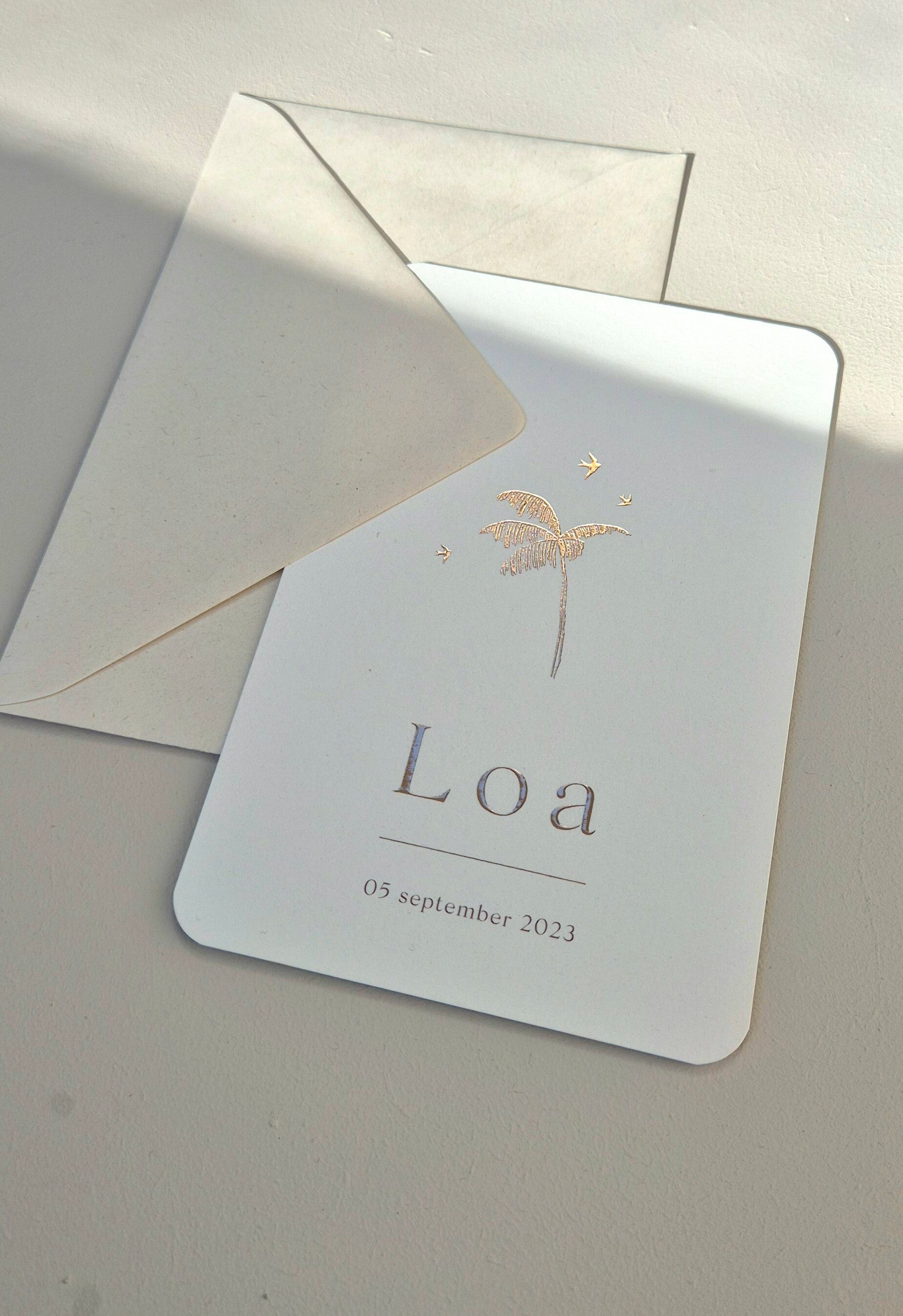 Een prachtig zandkleurig geboortekaartje met witte zomerse illustraties van een palmboom en een zonsopkomst. Door het rustige kleurgebruik is hij zowel voor de geboorte van jongens en meisjes. De afgeronde hoeken maakt hem volgens de trend van dit jaar.  