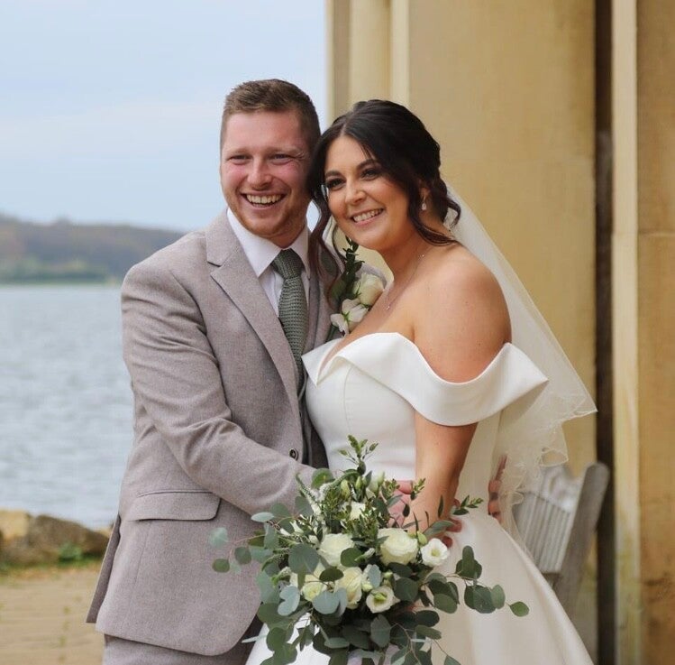 Wedding couple outside with Rutland  Water in the background