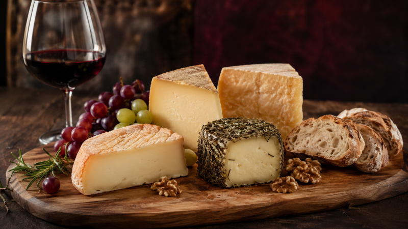 Tabla de quesos artesanos con vino, pan, uvas y frutos secos