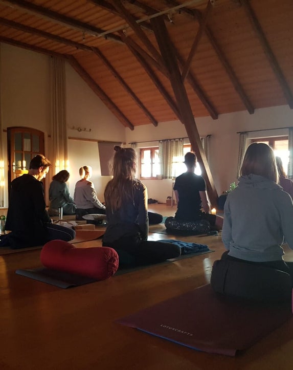 Eine Gruppe Menschen meditiert in einem Meditationsraum