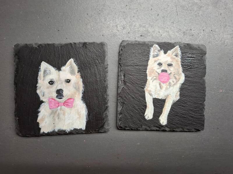 2 leistenen tegeltjes van 10 x 10 cm met op ieder tegeltje een hond , 1 met een strikje en 1 met een kauwgombal
