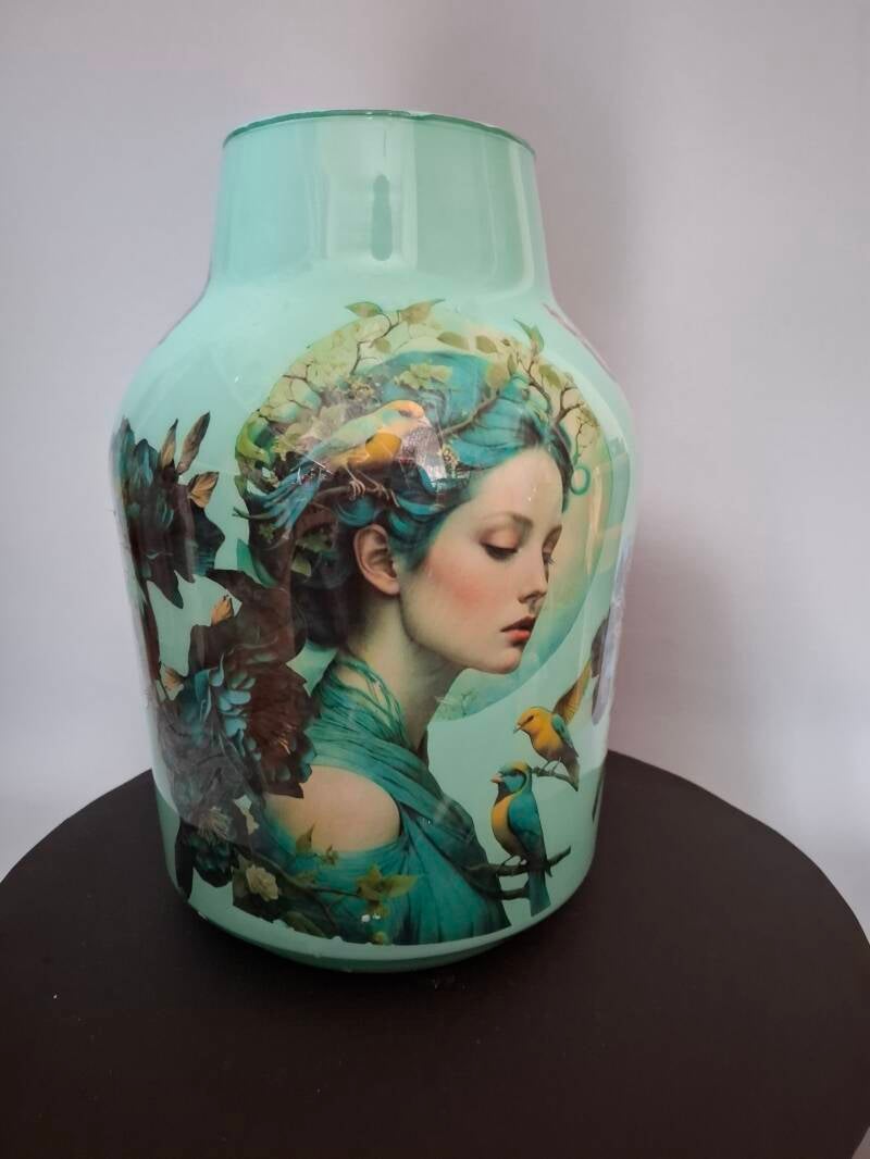Deze melkbus vorm vaas is aan de binnekant bewerkt met de afbeelding van een vrouw, bloemen en vogels, De vaas is mintgroen gespoten