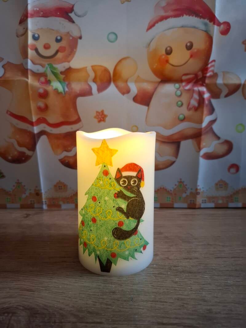 LED-kaarsen met kerstafbeeldingen in verschillende hoogtes, brandend met warm licht in een gezellige kerstsetting.