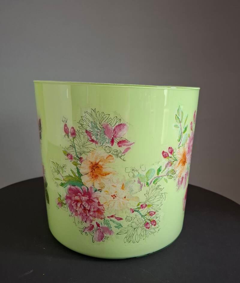 Groene glazen bloempot met subtiele bloemen en natuurlijke uitstraling