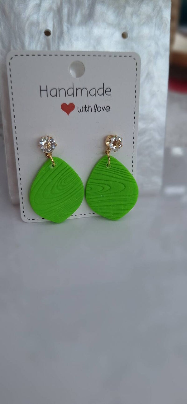 Groene ovalen oorringen met houtstructuur.