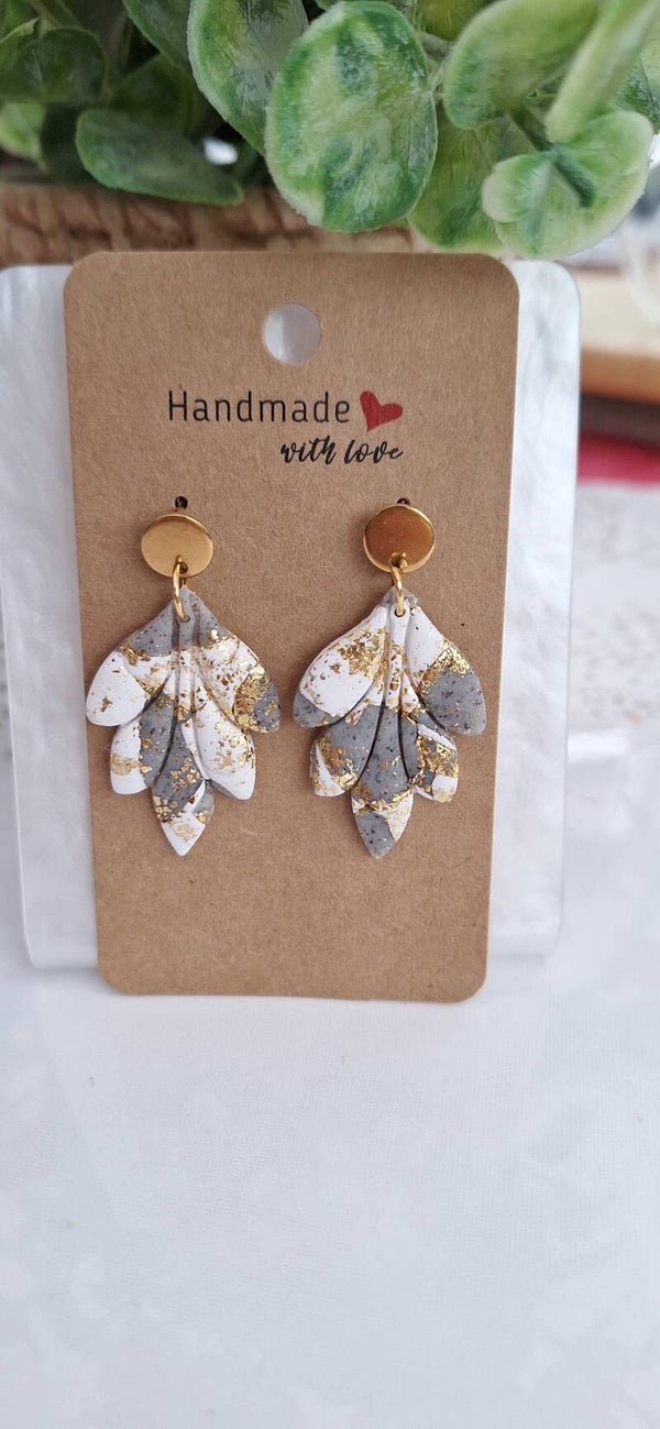 Wit-grijze oorbellen met gouden accent.