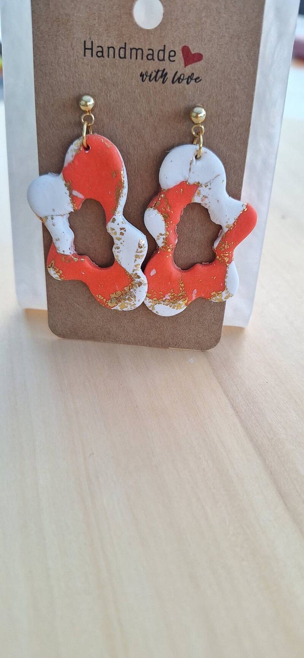 Oranje-witte wolkachtige oorbellen met goudkleurig accent.