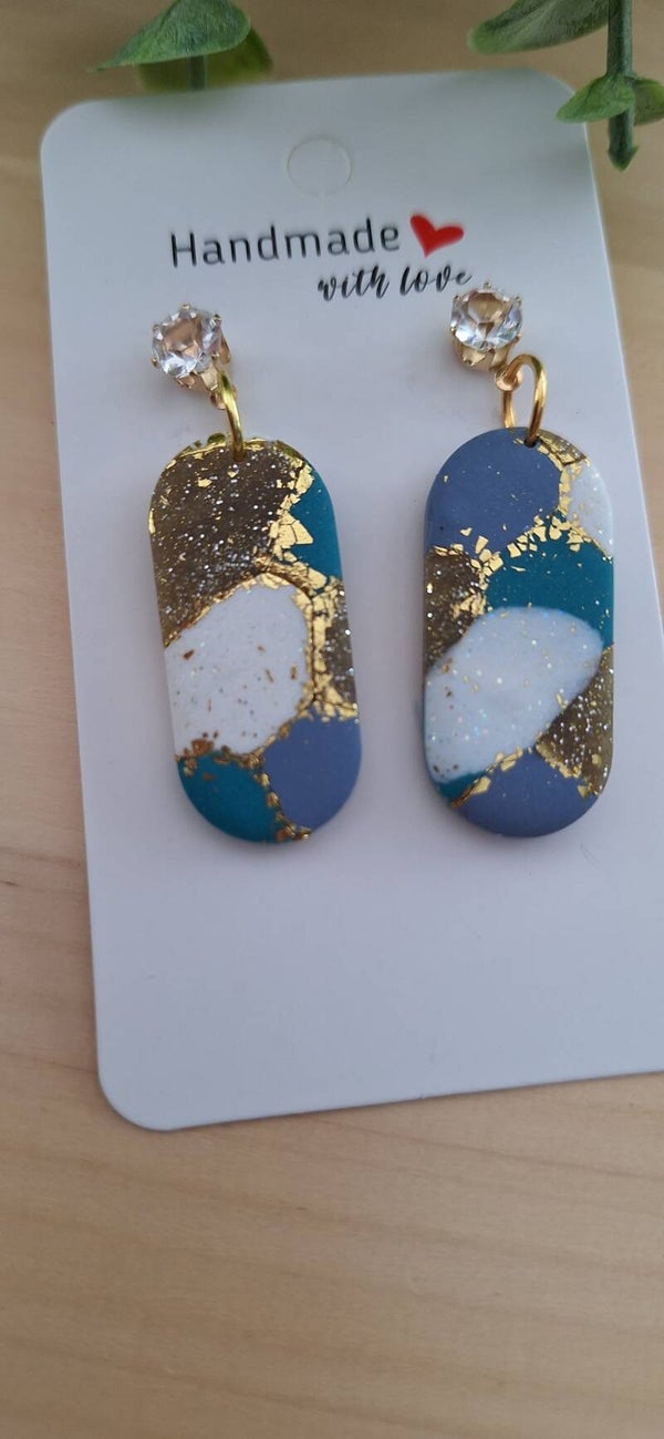 Handgemaakte oorbellen: langwerpig blauw/wit met gouden accenten