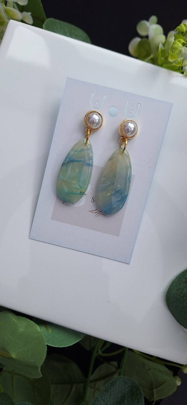 Zelfgemaakte oorbellen uit polymeerklei: ovale lichtblauwe translucent met parel