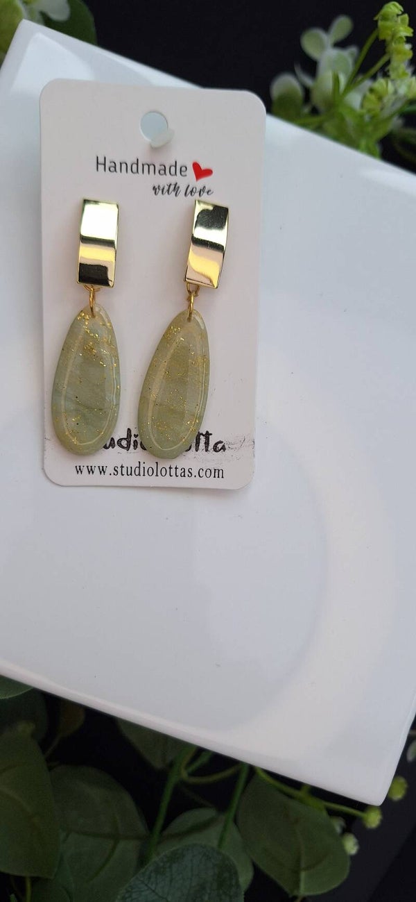 Zelfgemaakte oorbellen uit polymeerklei: lichtgroen-blauwe oorbellen met goudkleurige langwerpige steker