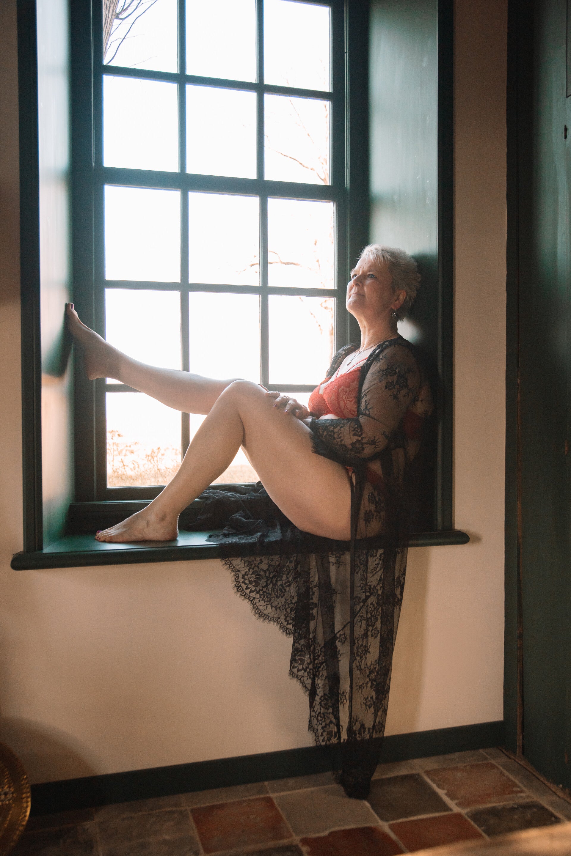 vrouw die poseert in de vensterbank van de prachtige locatie die de eigenaar afhuurt