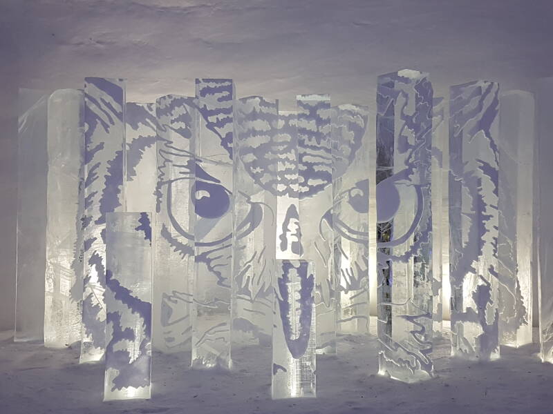 Glowing ice sculptures of mythical creatures in the SnowVillage illuminated by soft light.