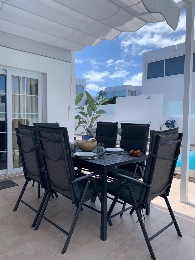 Shaded outdoor dining terrace with six chairs at Casa Havn