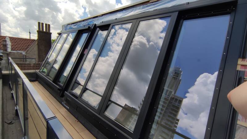 groot openschuivend glaspui in schuin dak glas over glas