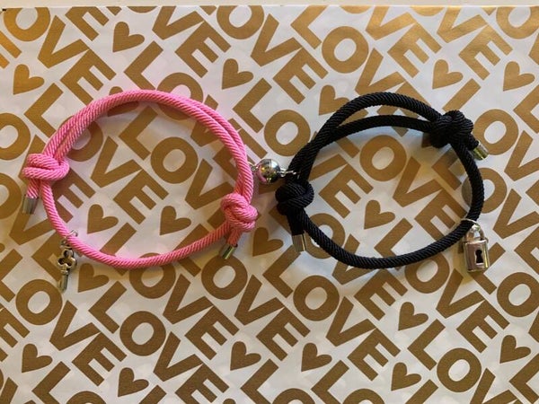 2 armbanden met magneet en slotje met sleutel. zwart/roze