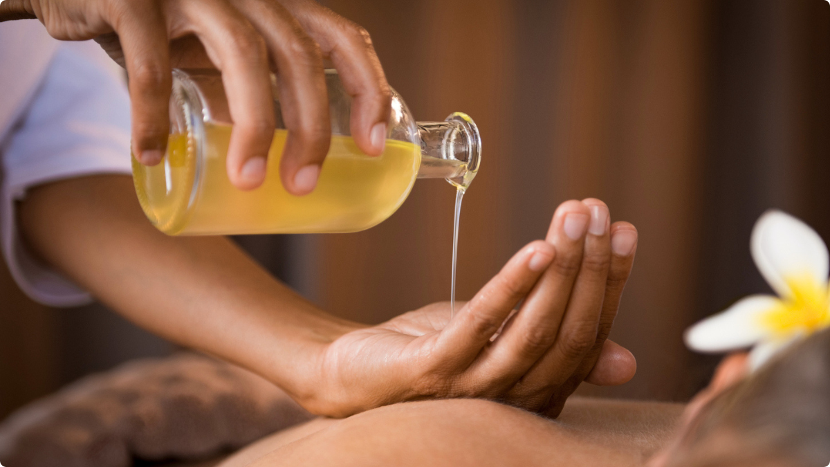 Huile versée dans une main près du corps avant un massage