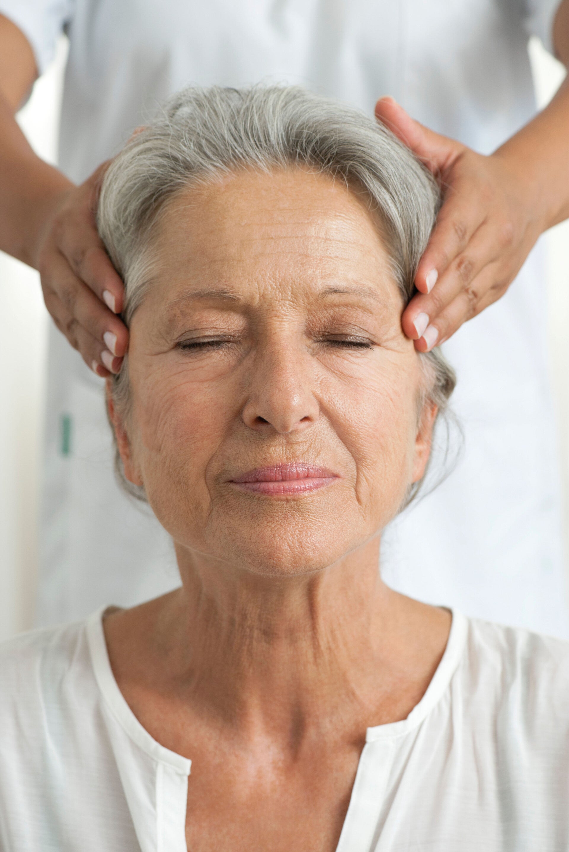 Massage apaisant de la tête et du visage chez une personne âgée