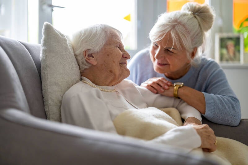 personne agée allongée sur son fauteuil entrain d' échanger