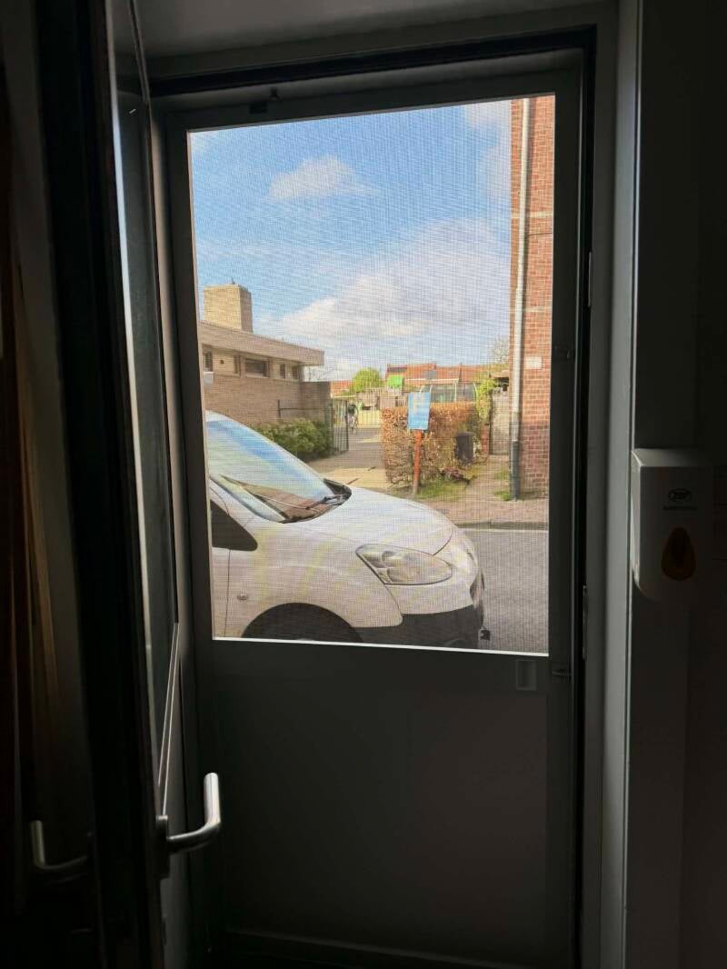 Plaatsing hordeur achterdeur met extra stevig petscreen en vast paneel onderaan in RAL kleur zoals de deur in Wervik / West-Vlaanderen door firma Neyrinck