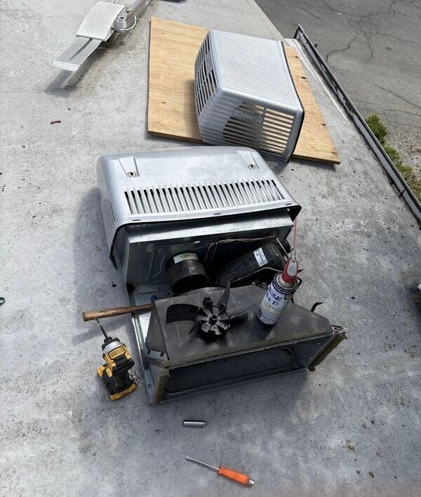 Coleman Mach RV Air Conditioner unit opened for on-site repair in Stockton CA. Mobile RV technician performing AC service with tools and parts visible - veteran-owned On-Site Mobile RV Repair