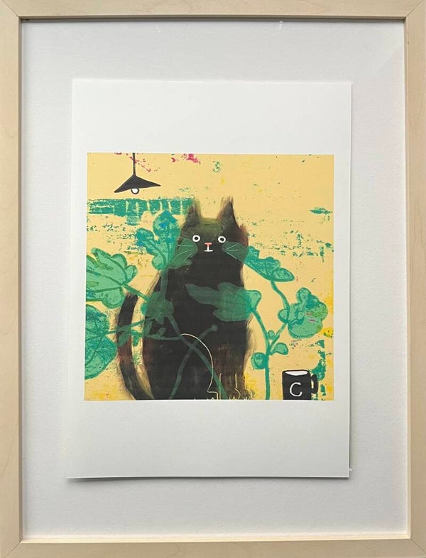 Black cat print behind plant (no frame).