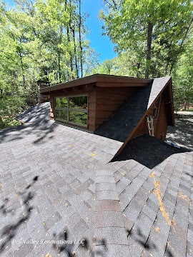 House roof with dormer window and ladder positioned for inspection or maintenance.