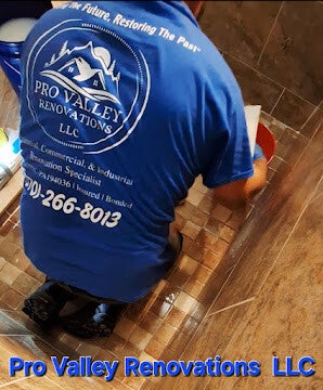 Renovation professional working on tile installation inside a shower area.