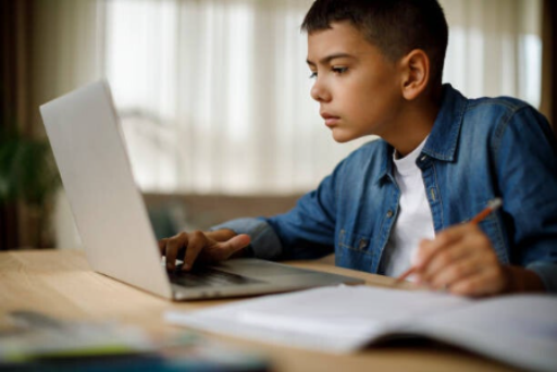 Focused student working at a computer preparing for UK entrance exams.