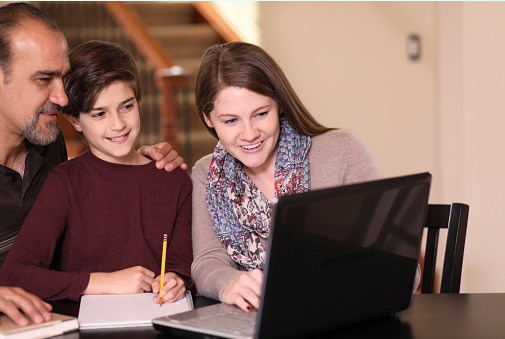 Smiling parents receiving pretest tutoring feedback on their laptop screen.