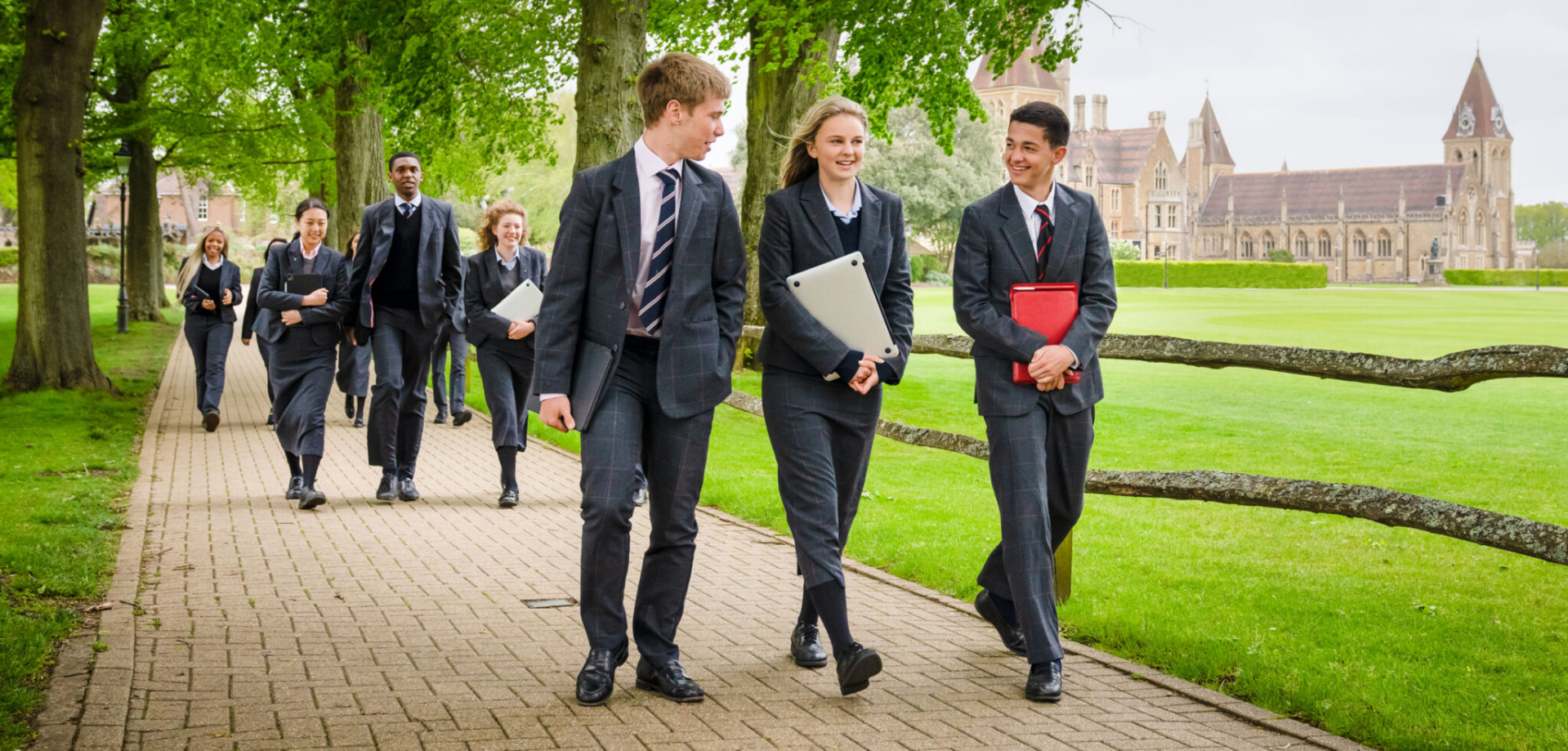 Smartly dressed senior school students walking across campus between academic lessons.