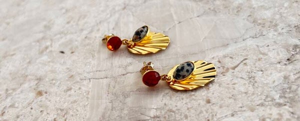 2 ovale golvende hangers van verguld met 24 k fijn goud met goeden knopjes kleur oranje rood en een panter print wit met zwarte vlekjes.