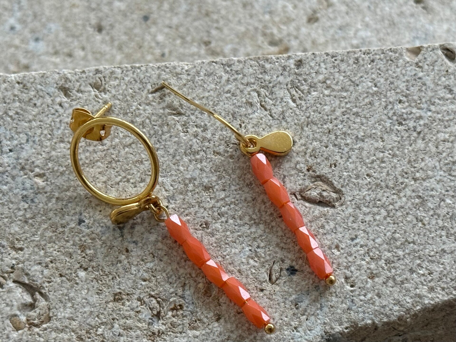 Gouden asymmetrische oorbellen 18K met oranje roze kralen blinkend