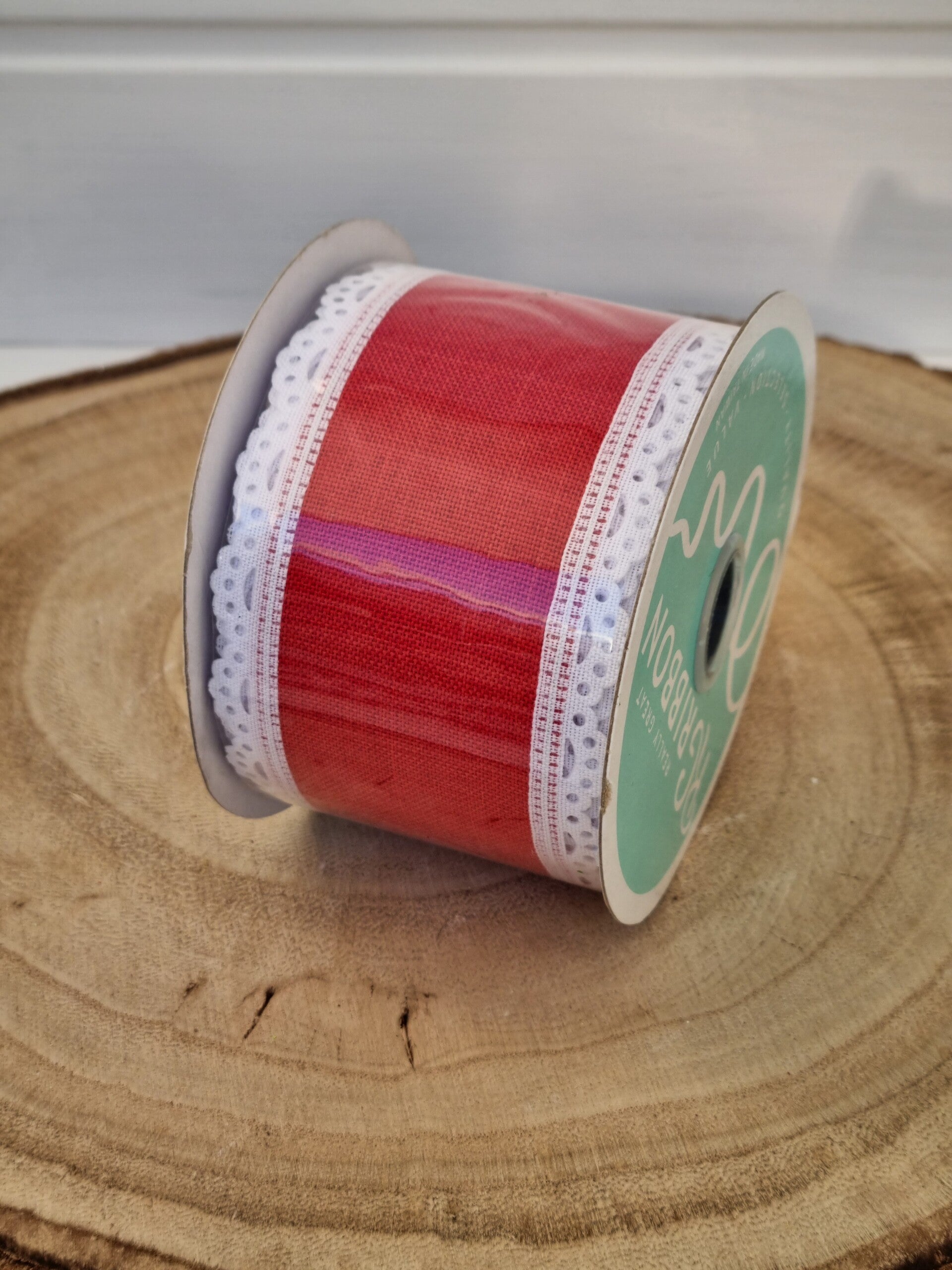 Rotes Schleifenband mit weißen Spitze.