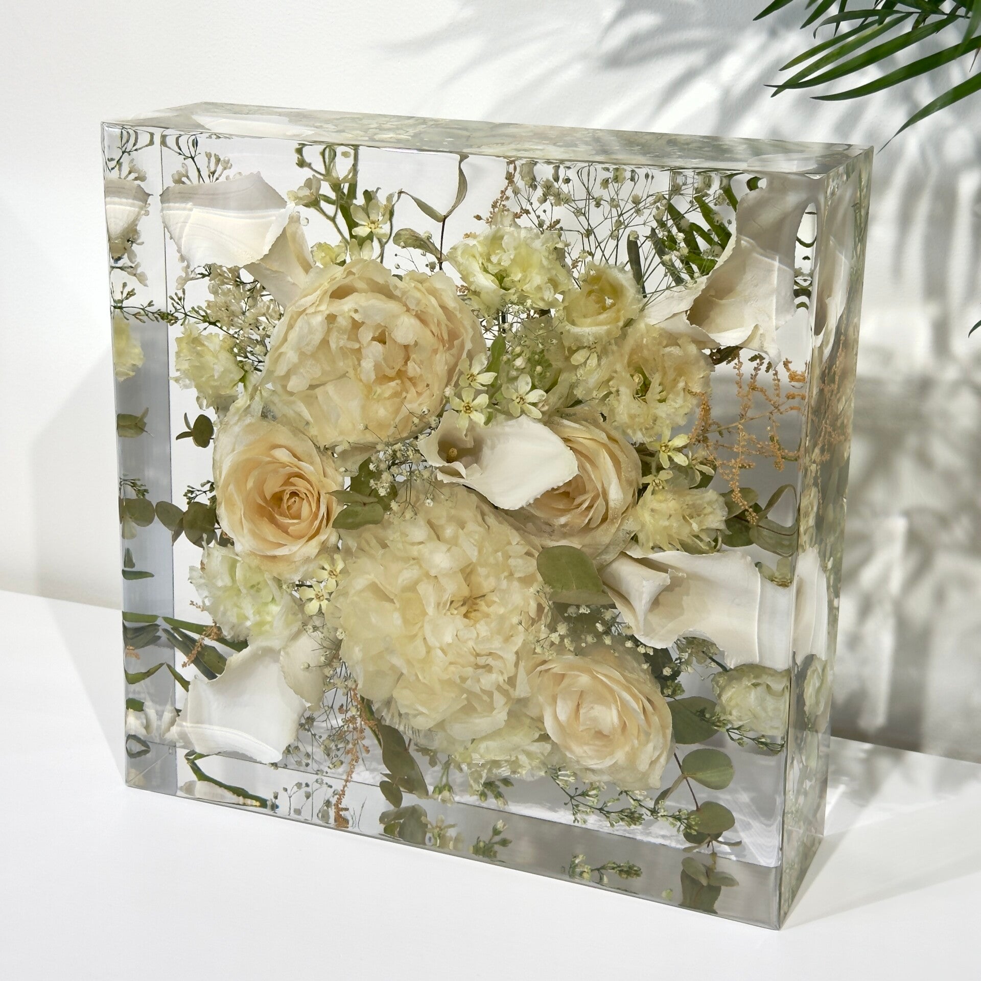 Vierkant van epoxy met wit bruidsboeket.