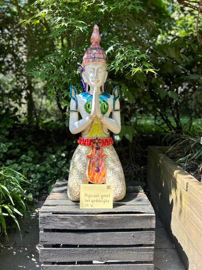 Gemozaiekt buddha  beeld in namaskara mudra houding 