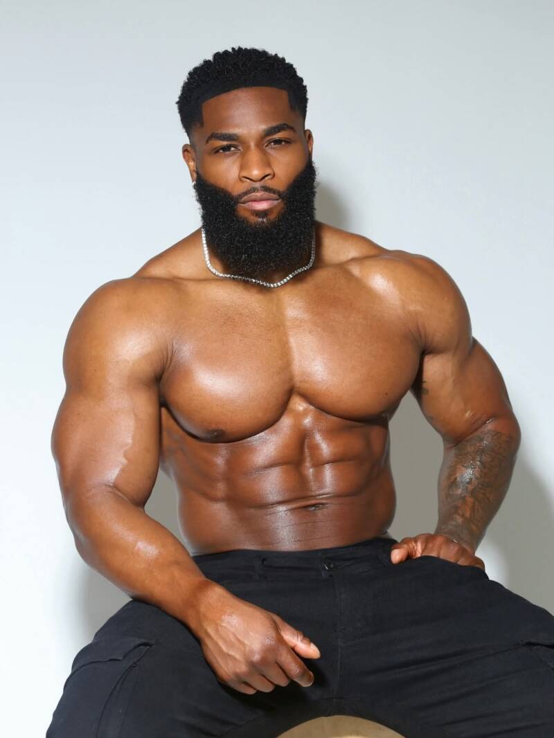Jaivron Joseph aka prosper fitness sitting shirtless showing off buff chiseled body with confident pose 