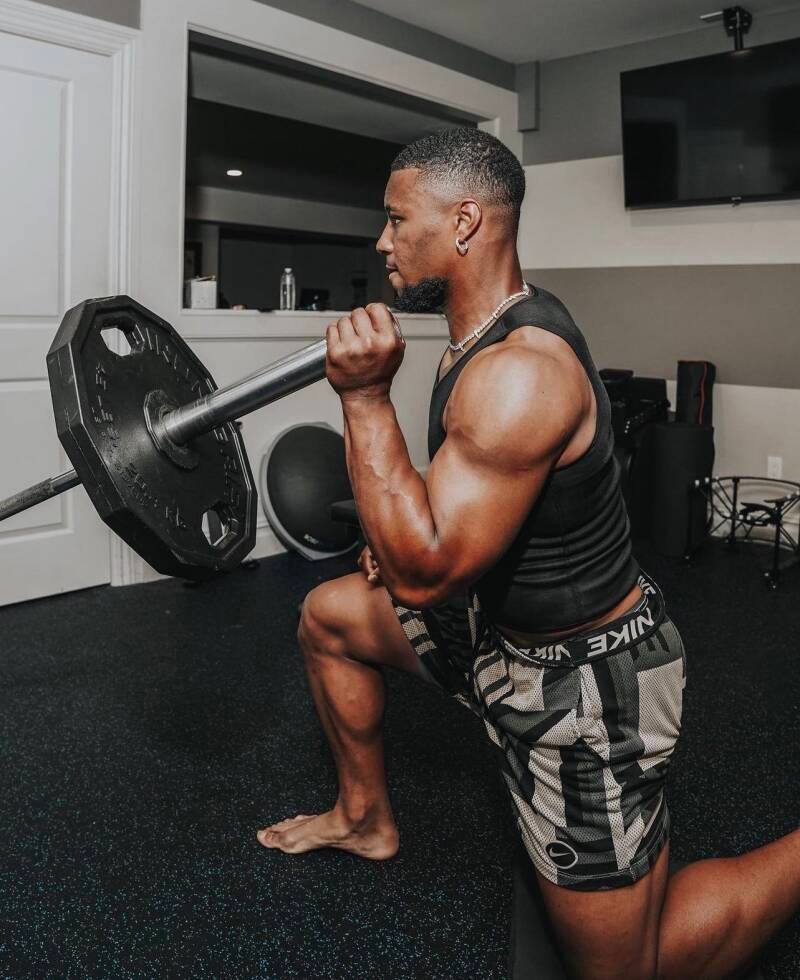 Muscular body football player Saquon Barkley showing off leg definition and strong masculine veined feet while working out.