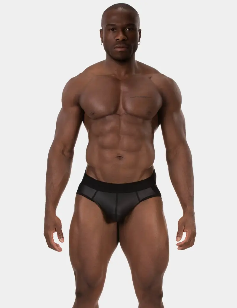 Masculine black male model with ten pack abs, shredded body, wearing tight fitted jock strap.