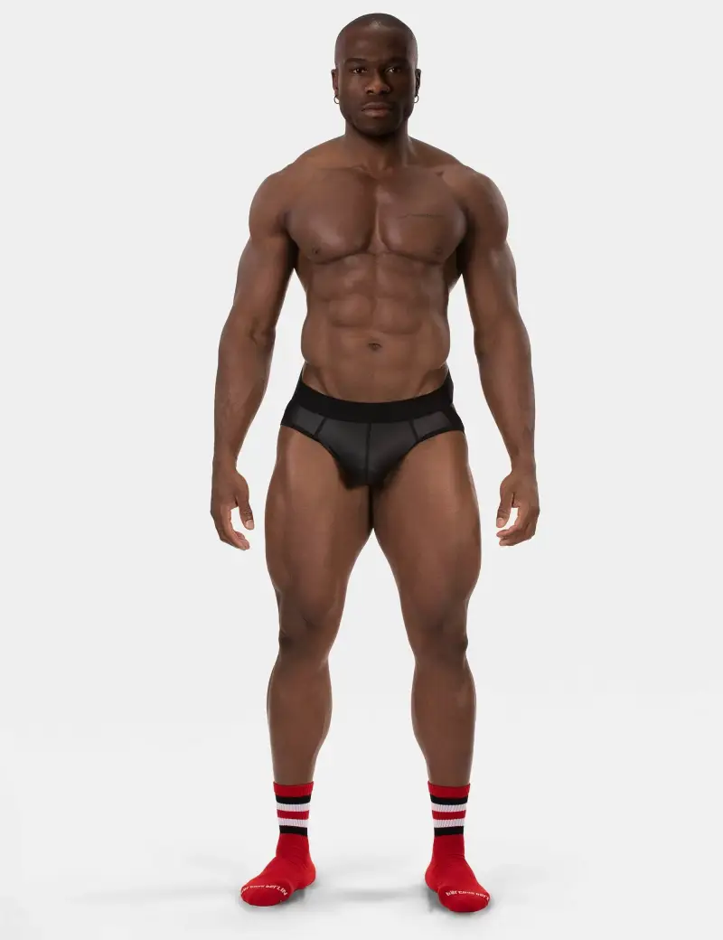 Full body view of fitness coaches shredded physiques against a white background, while wearing fitted underwear.