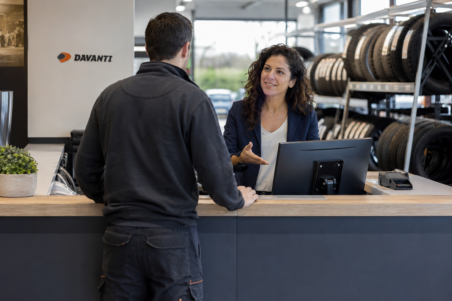 Klant die praat met een receptioniste bij een bandenmonteur met Davanti-banden