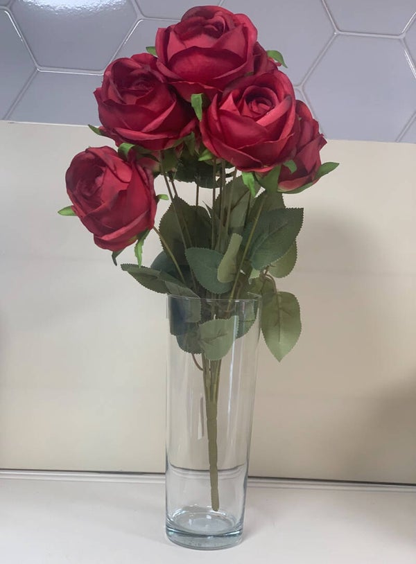 Bouquet de roses rouges artificielles dans vase en verre